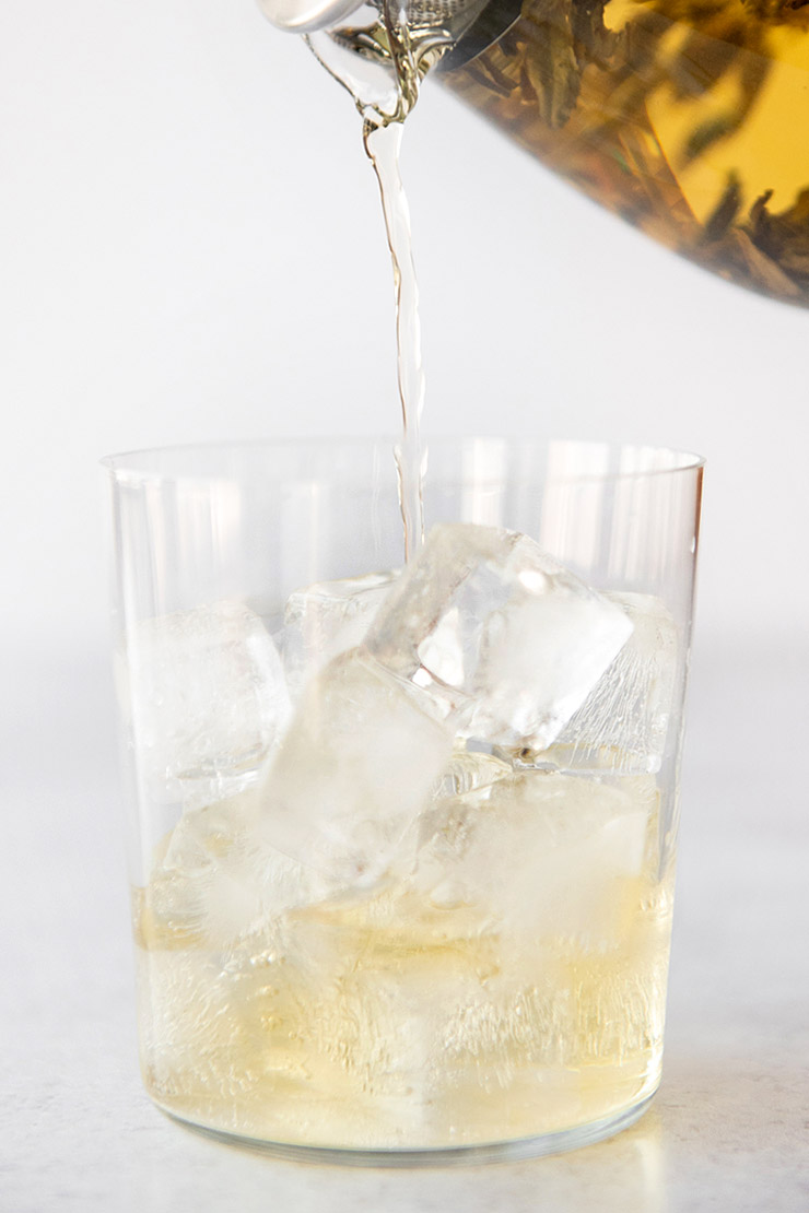 Pouring cold brewed tea into a cup with ice.