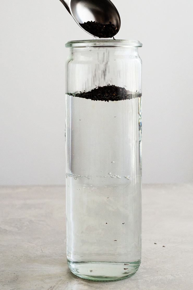 Loose tea spooned into a tall jar with water