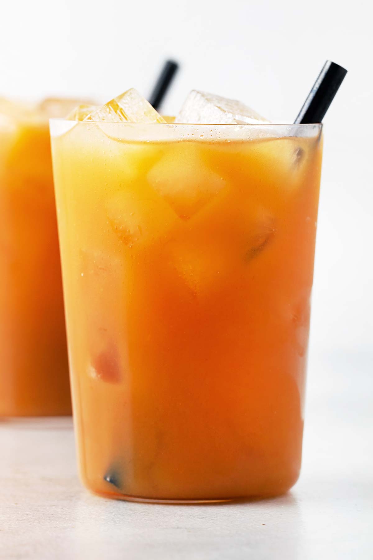 Apricot Iced Tea in clear glass with straw.