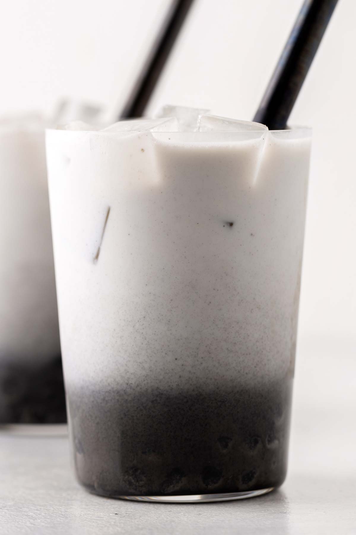 Black Sesame Bubble Tea (Black Sesame Boba Milk Tea) in a clear glass with wide straw.