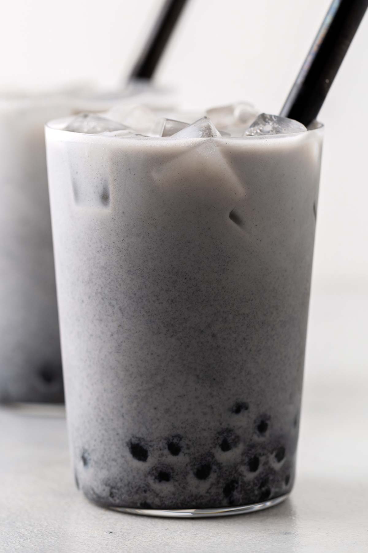 Black Sesame Bubble Tea (Black Sesame Boba Milk Tea) in a clear glass with wide straw.