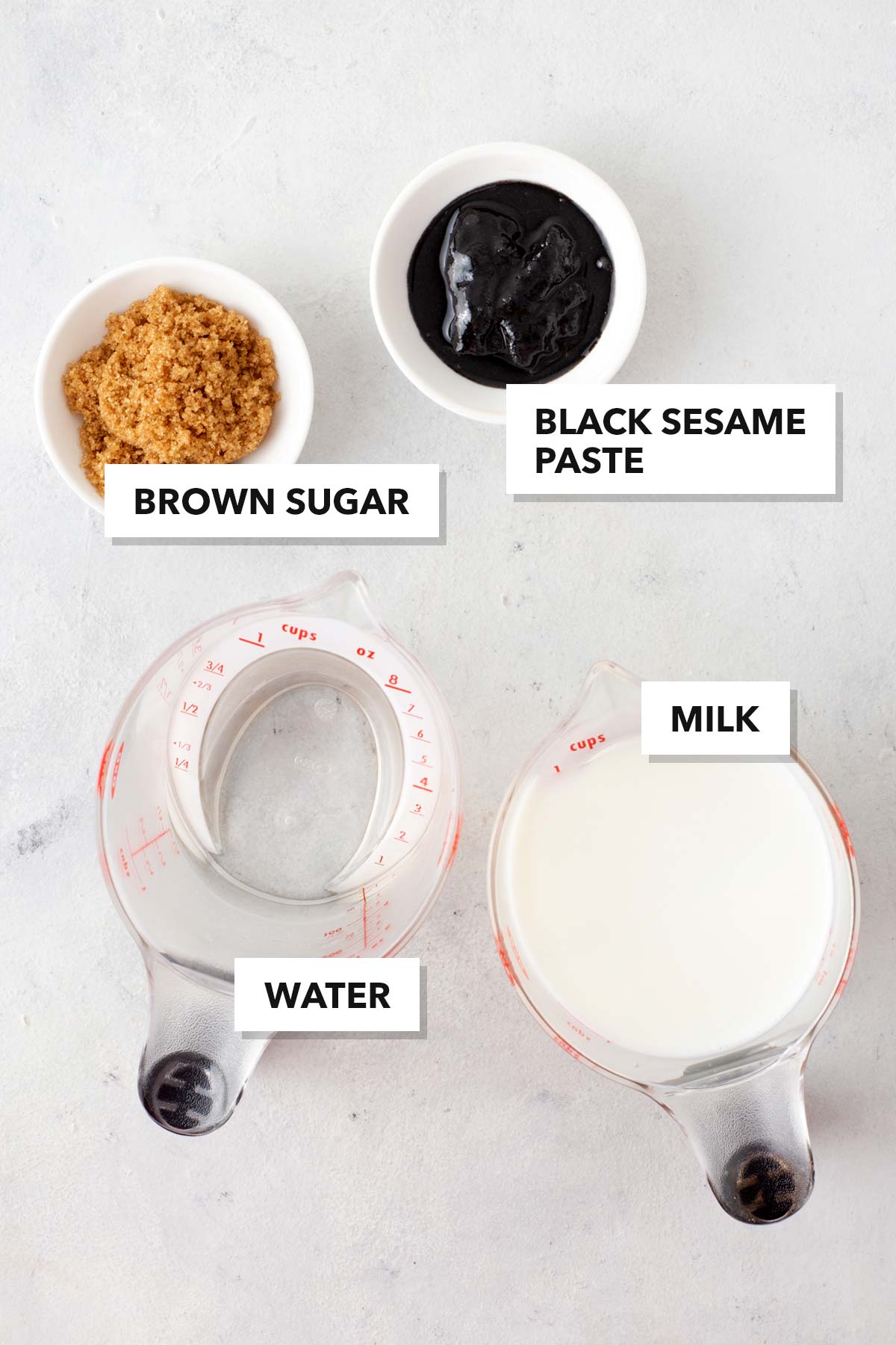 Black Sesame Latte ingredients measured in cups and labeled on a table.