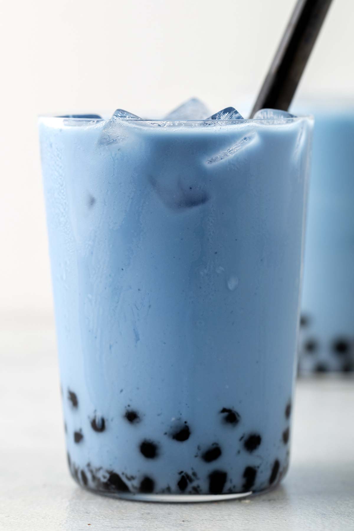 Butterfly Pea Flower Bubble Tea (Butterfly Pea Flower Milk Tea with Boba) fully assembled and solid blue color drink with boba at the bottom and ice on top.