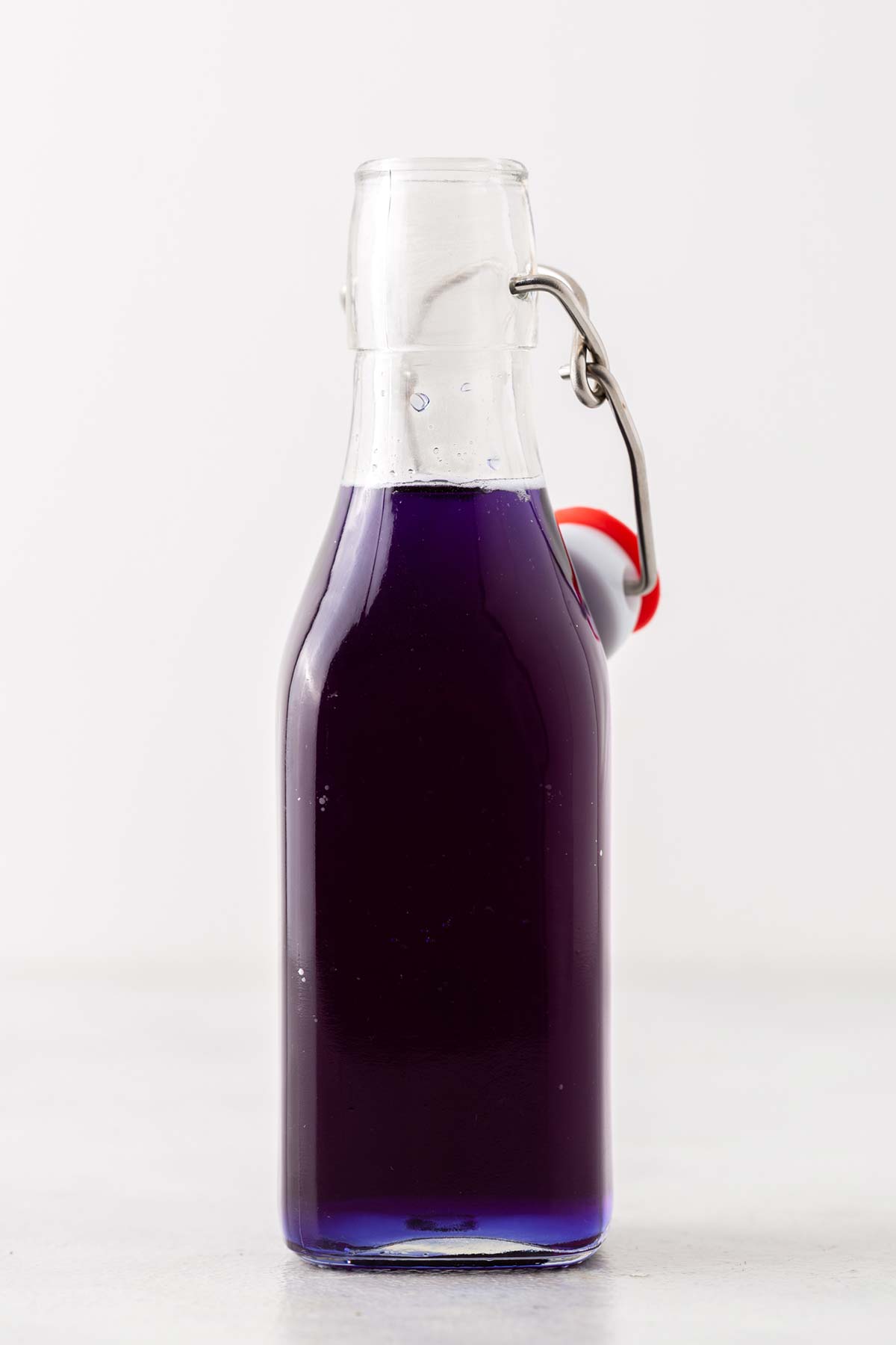 Butterfly Pea Flower Syrup in clear glass bottle.