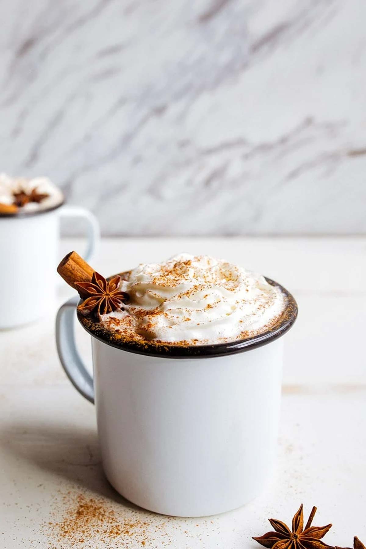 Chai Hot Chocolate with whipped cream in a white mug.