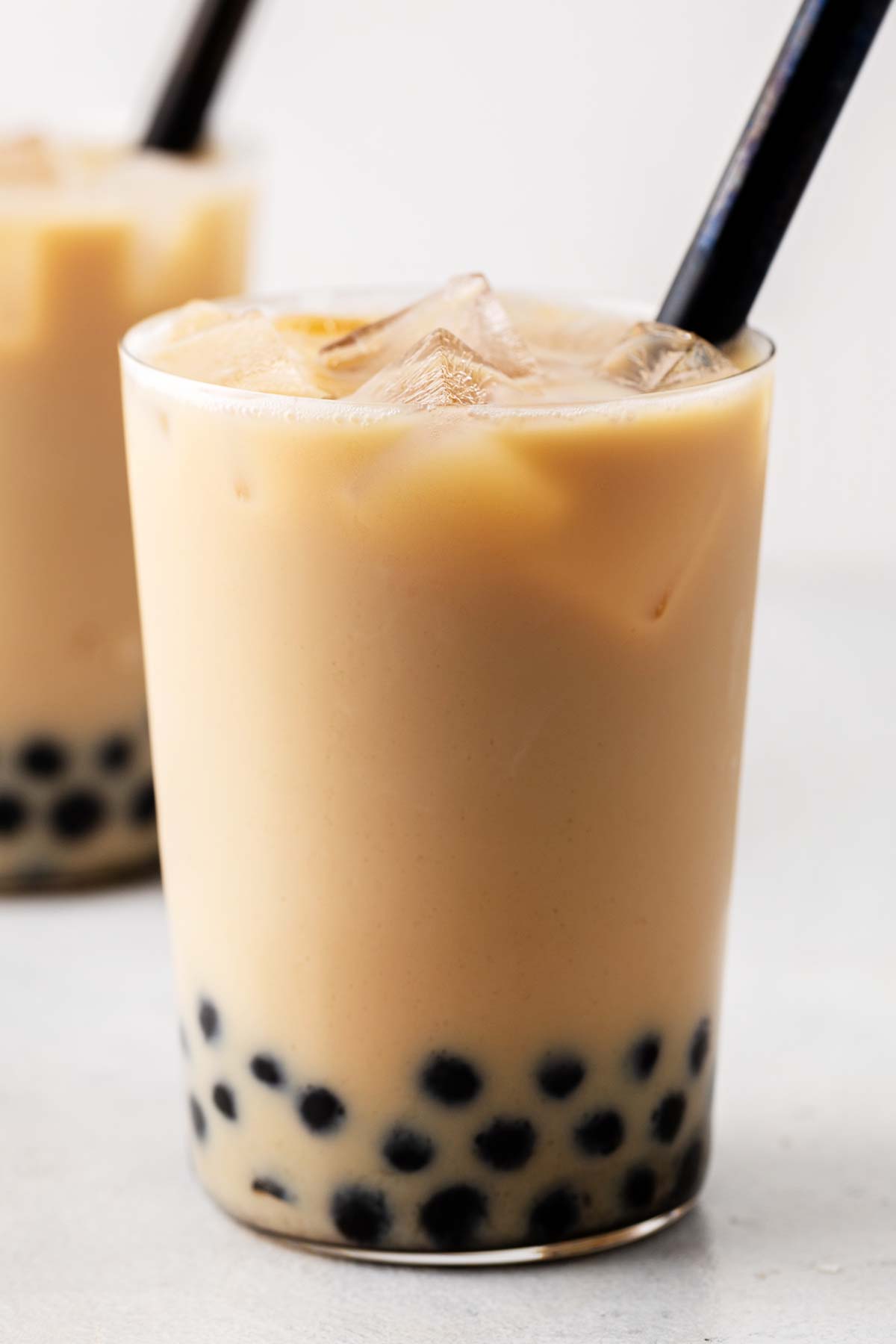 Earl Grey Bubble Tea in a glass with a black straw.