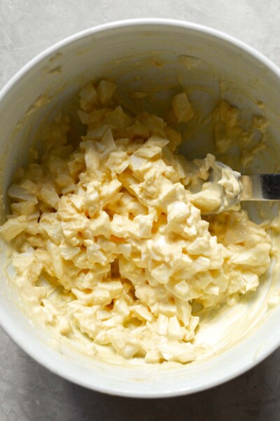 Chopped eggs, mustard, mayo, and salt in a bowl.