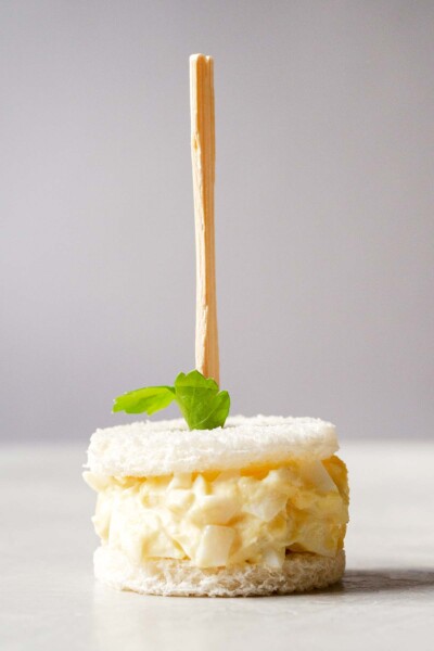 Egg salad sandwich with a skewer through it. 