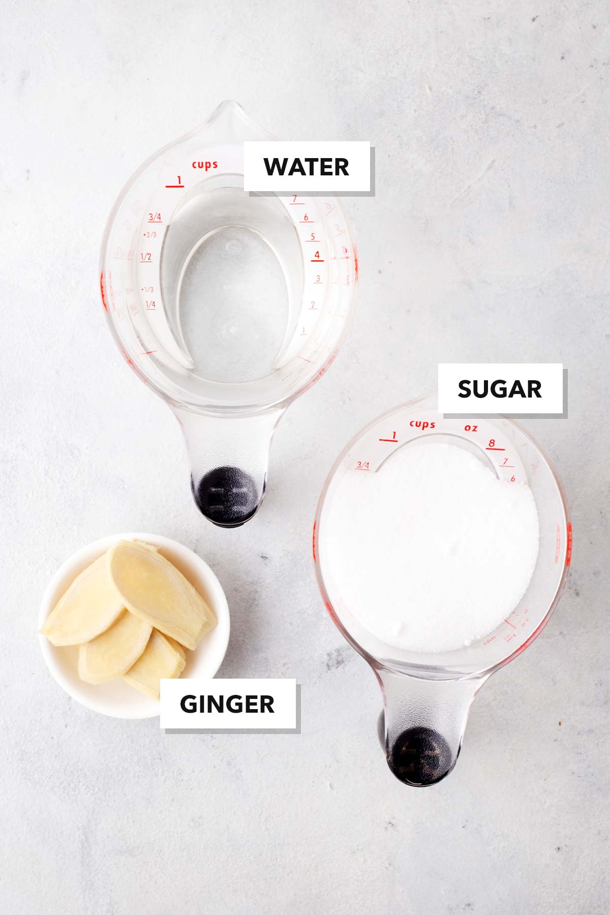 Simple Homemade Ginger Syrup ingredients in measuring cups and labeled.
