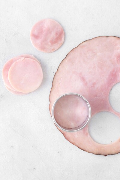 Ham being cut into circles with cookie cutter.