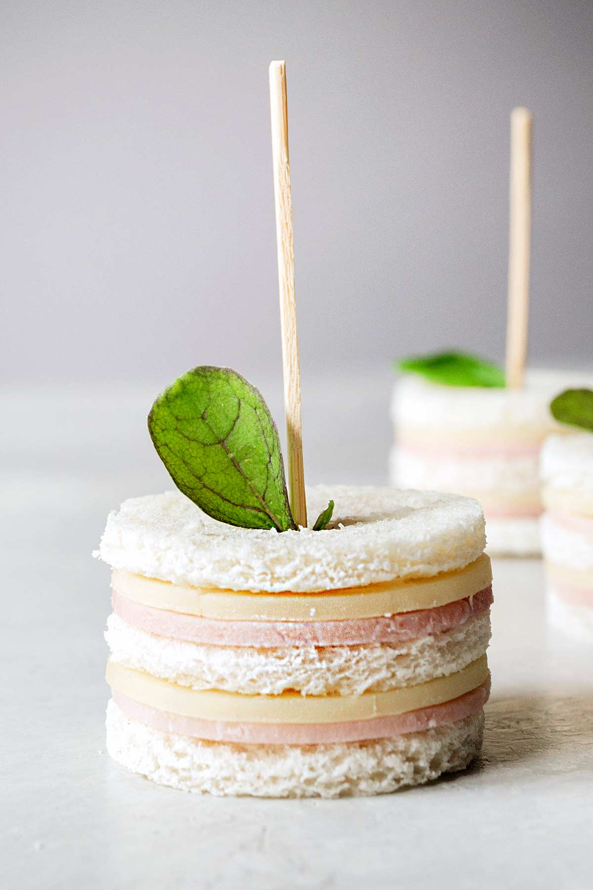 Ham and cheese tea sandwiches with cocktail forks.