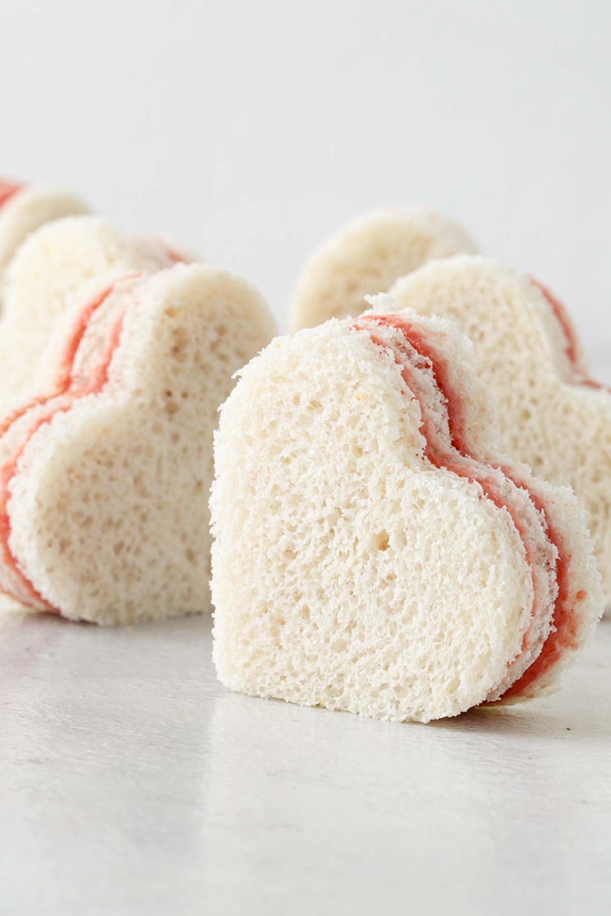 Heart-shaped tea sandwiches with strawberry filling.
