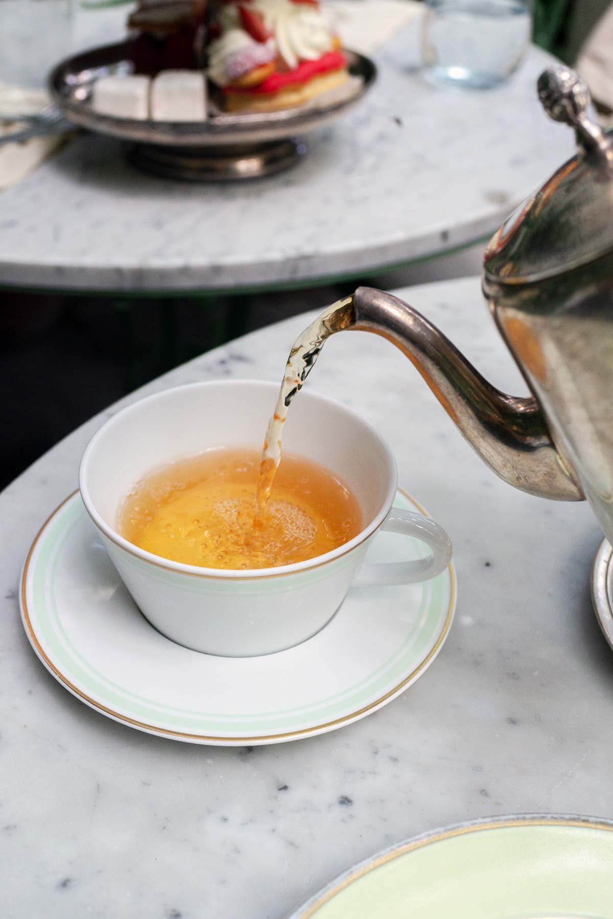 Pouring tea into a cup at Laduree Soho.