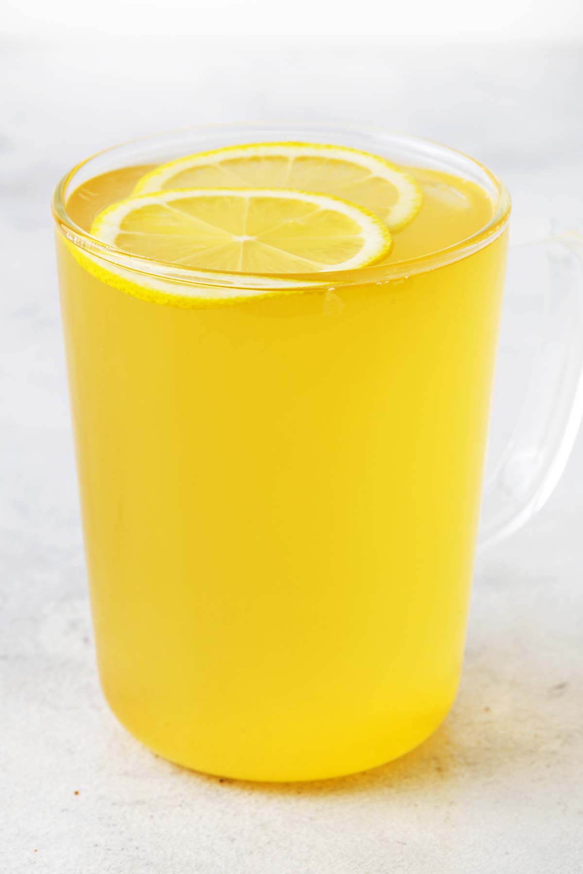 Lemon tea with lemon slices in clear mug.