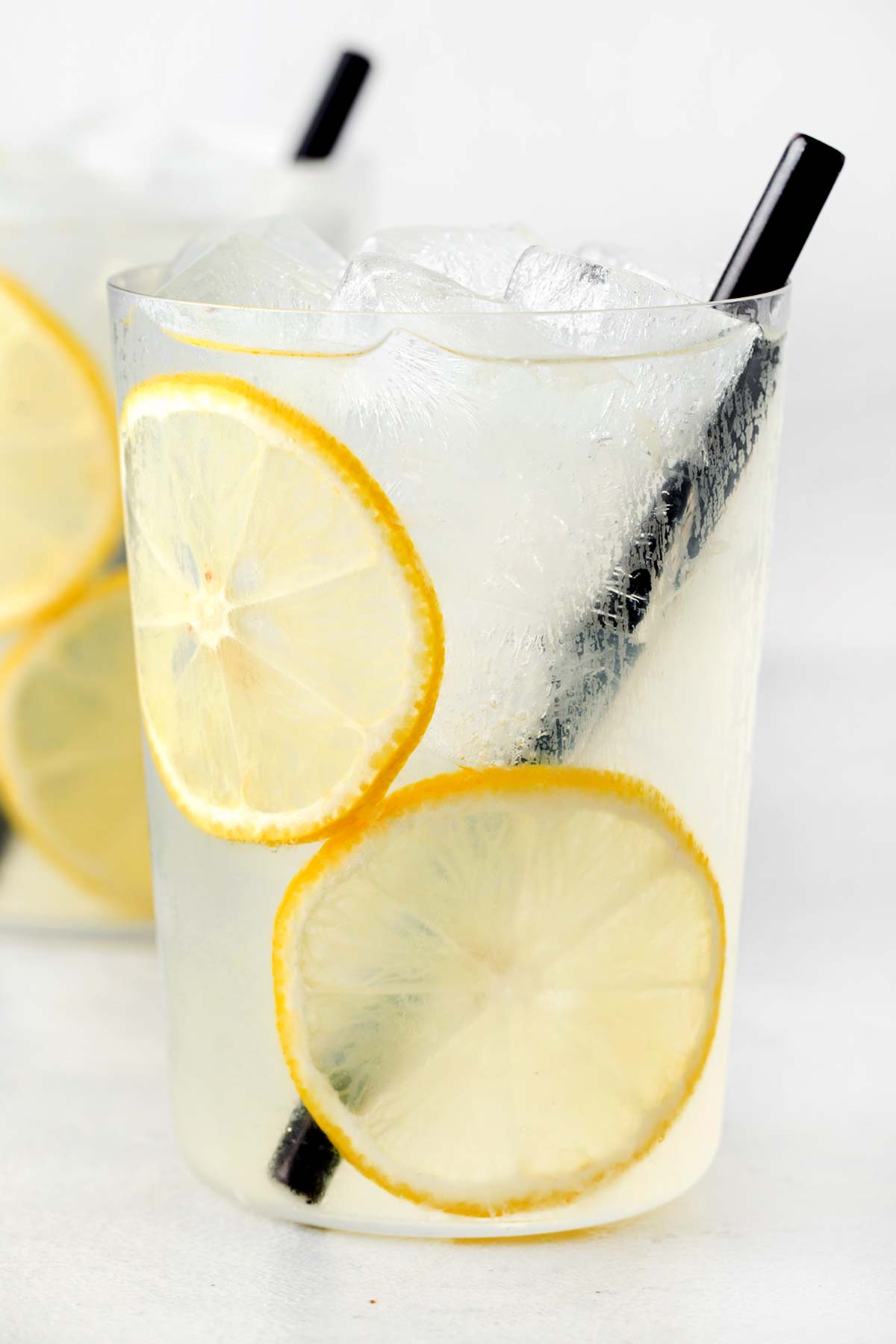 Homemade lemonade in clear glass with straw.