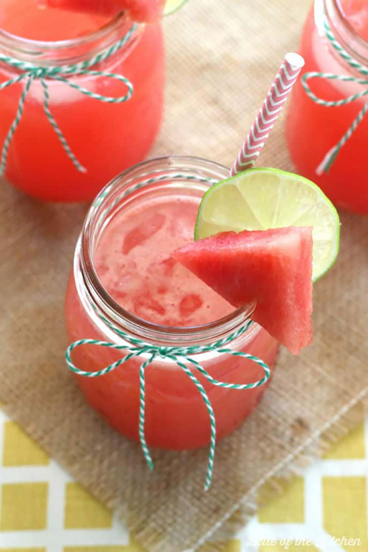 Watermelon lemonade in mason jar cups with straws.