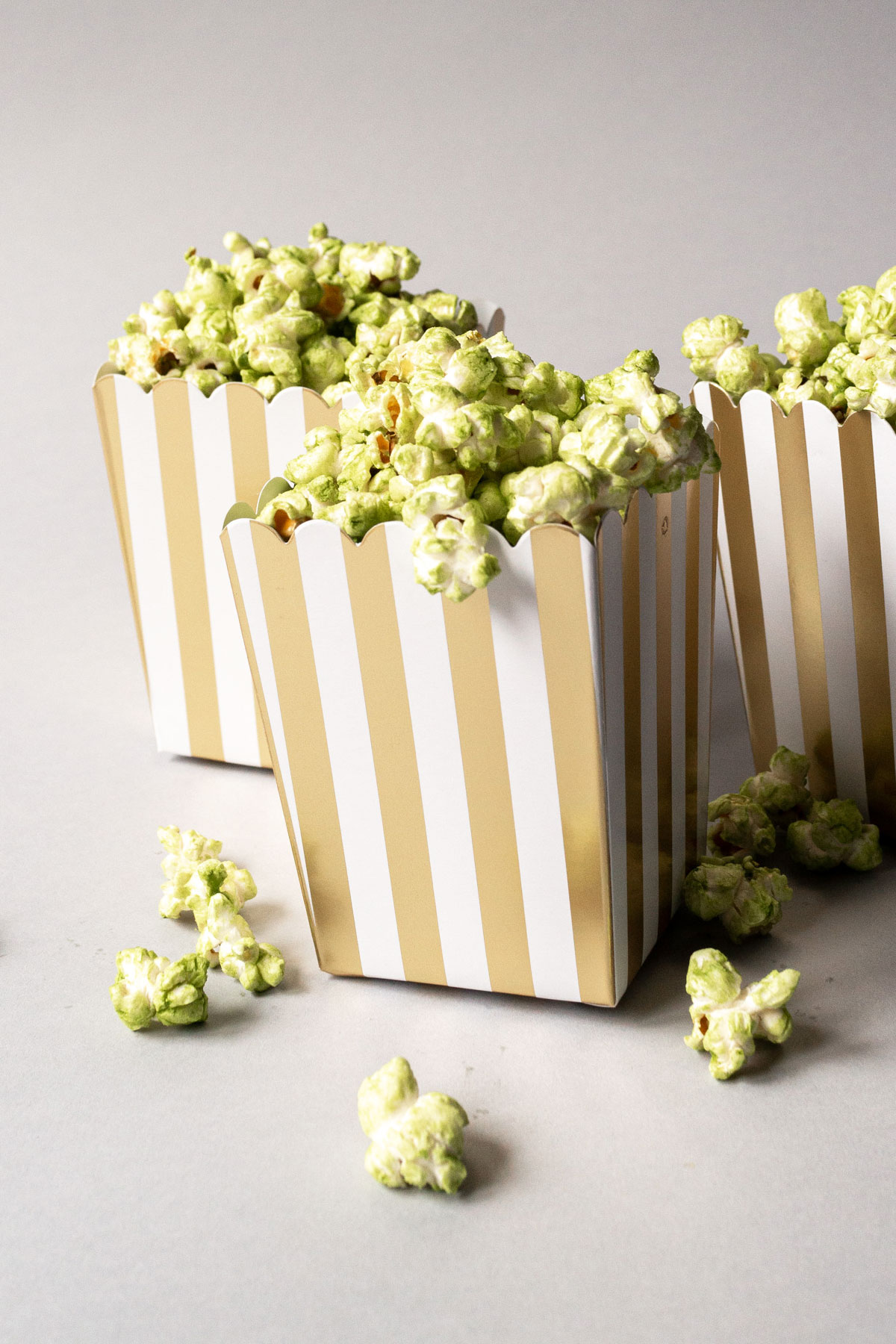 Matcha popcorn in striped popcorn boxes.