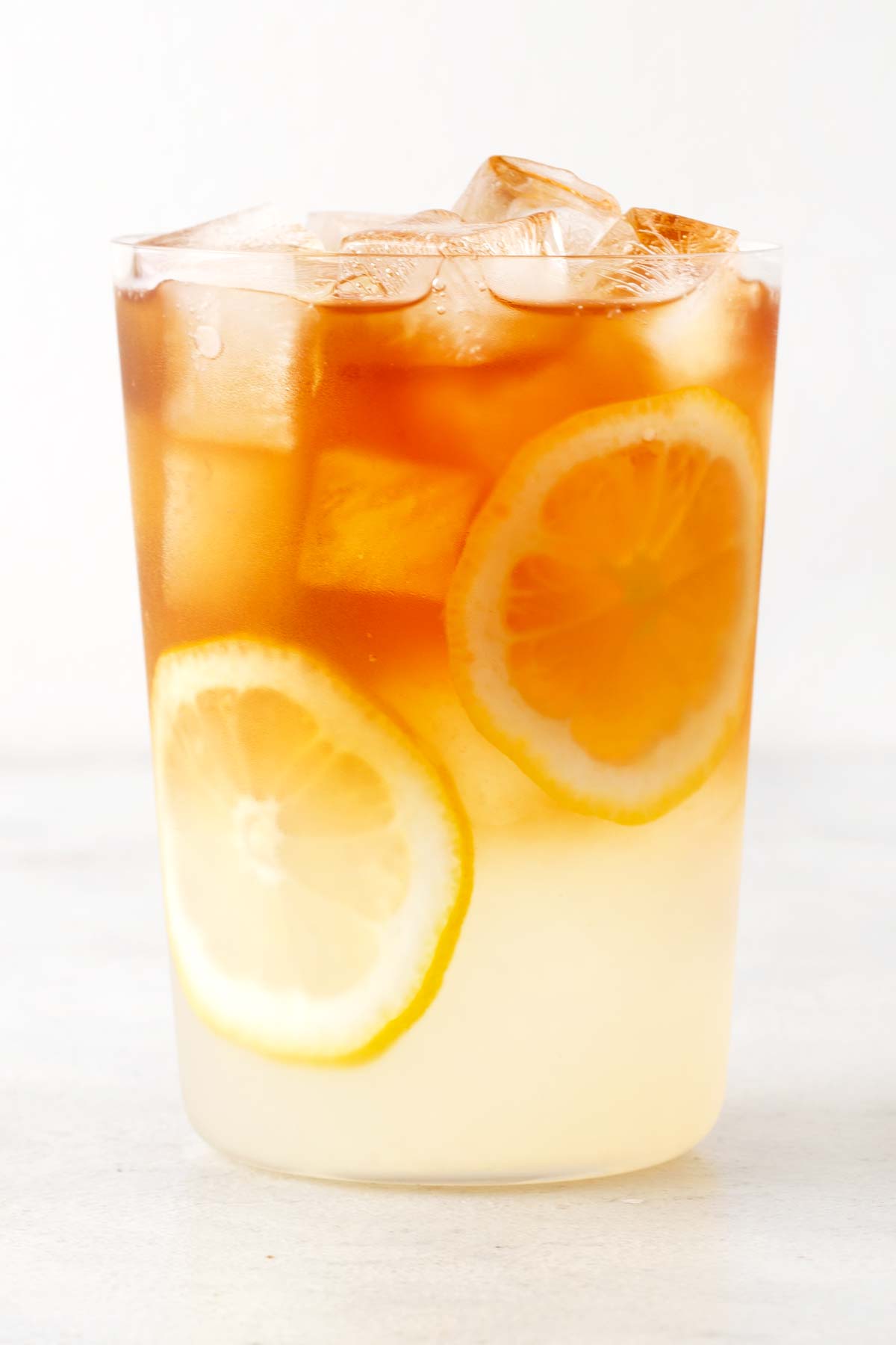 Mint Lemonade in clear glass with sliced lemons.