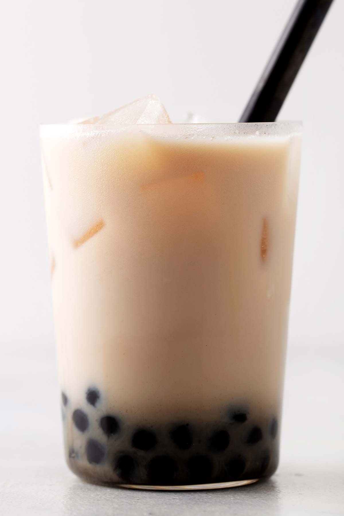 Oolong Bubble Tea in a glass with a wide straw.