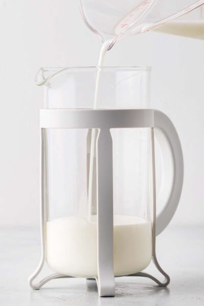 Pouring milk and cream into a French press.