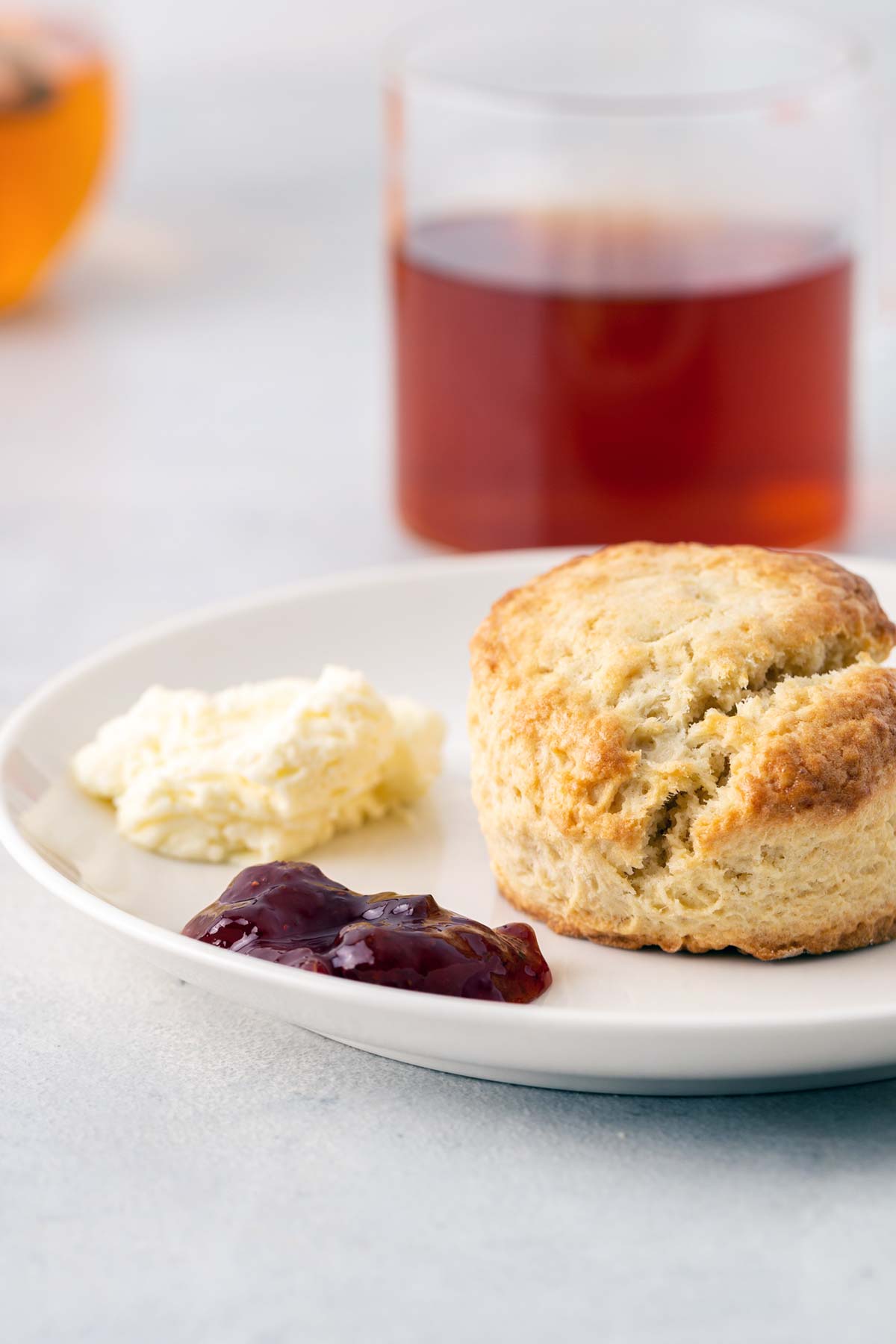 Scone on plate with clotted cream and jam.