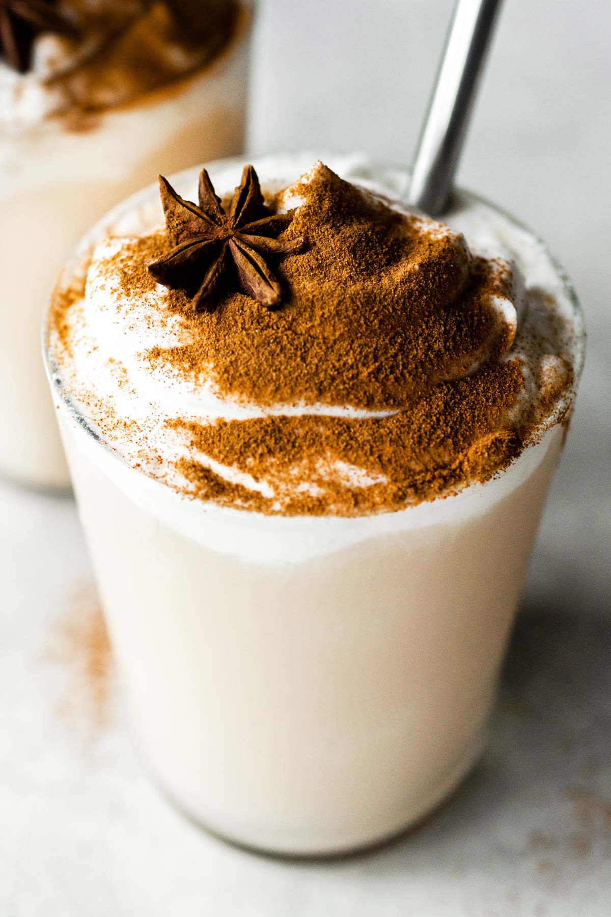 Starbucks Chai Frappuccino in a clear cup topped with whipped cream and ground cinnamon.