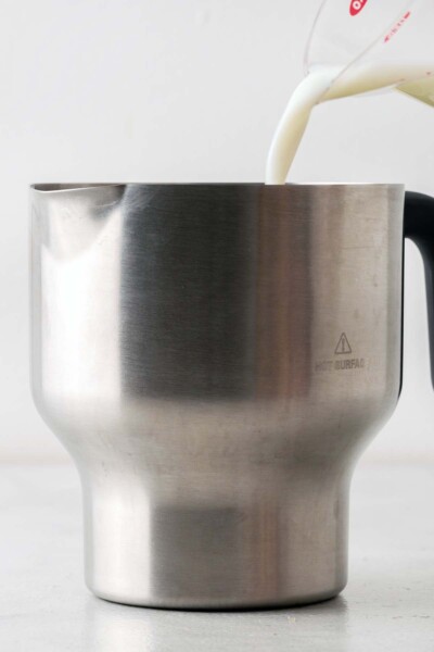 Pouring milk into an electric kettle. 