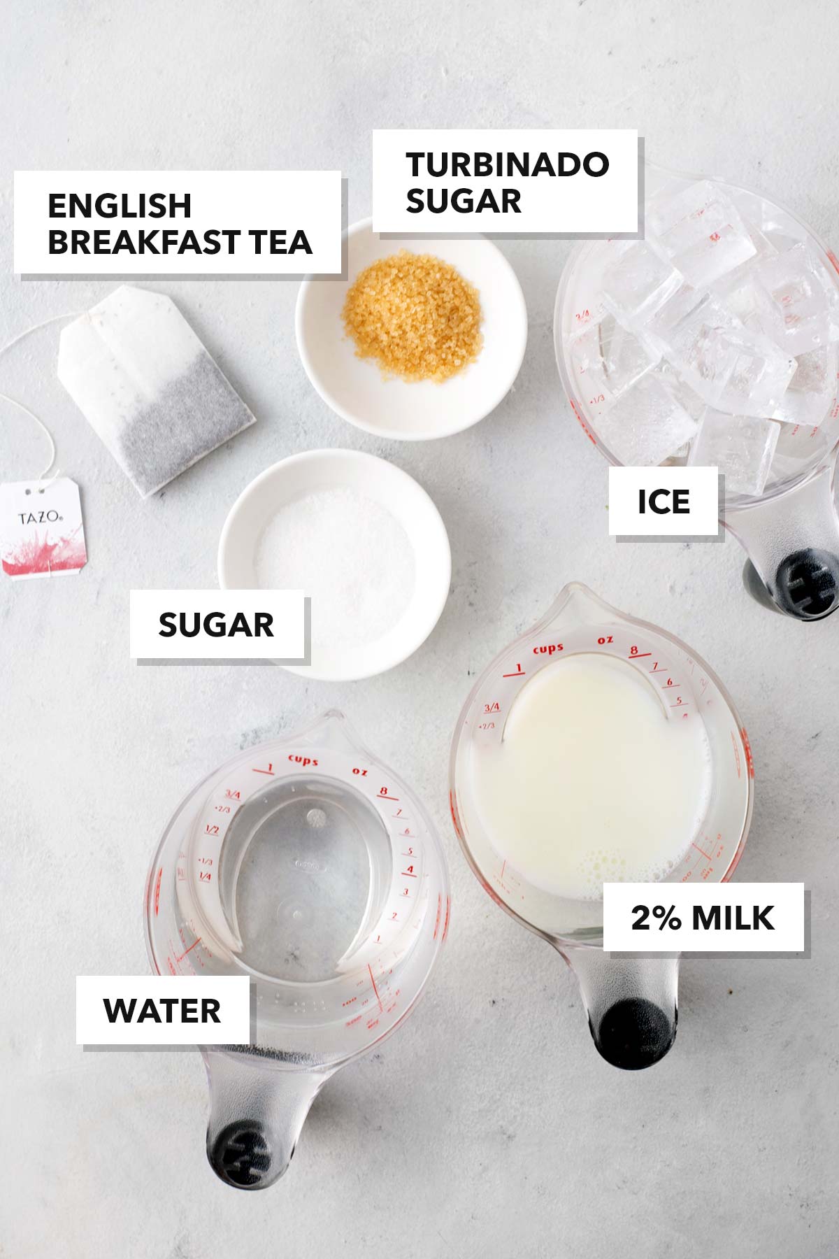 Starbucks Iced Royal English Breakfast Tea Latte Copycat recipe ingredients in measuring cups with labels on a table.