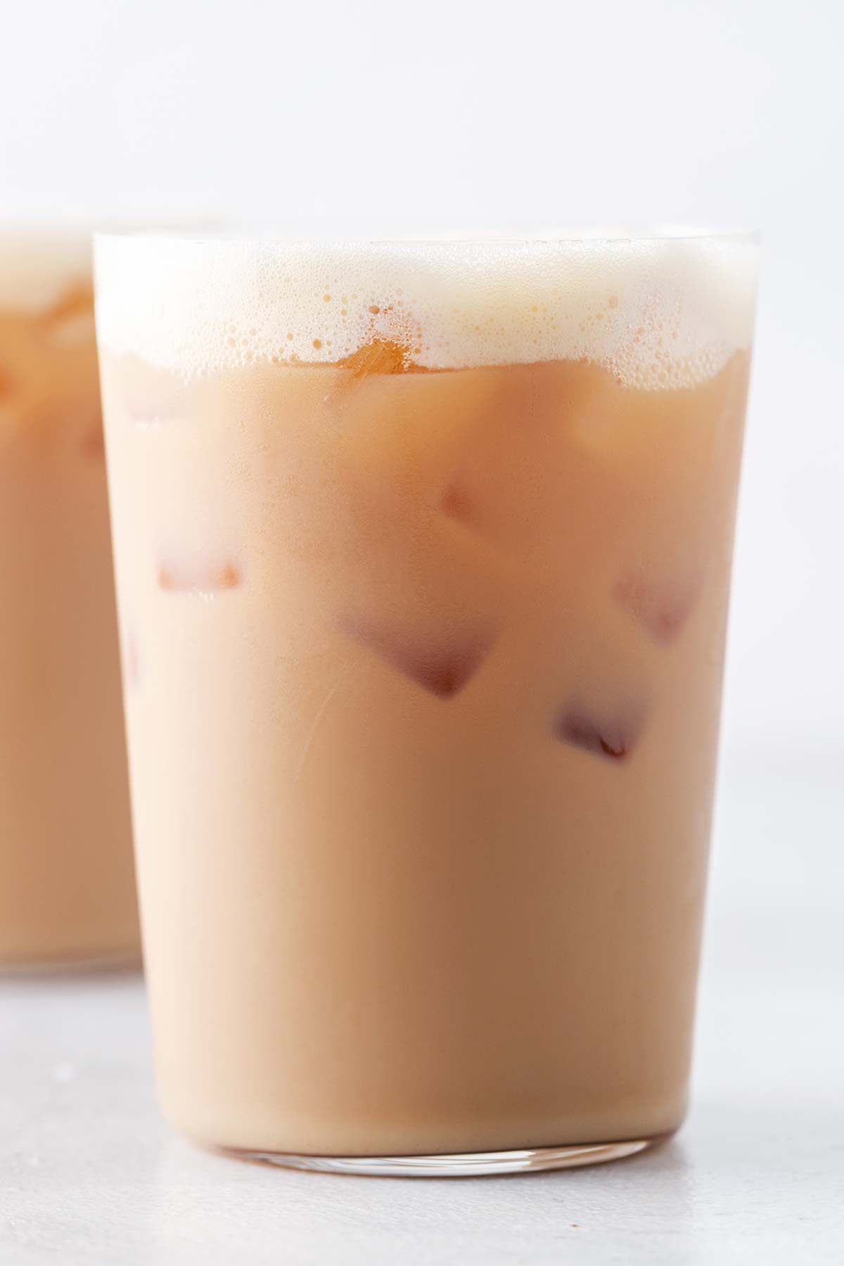 Starbucks Iced Royal English Breakfast Tea Latte Copycat in a clear glass with ice and foam on top.