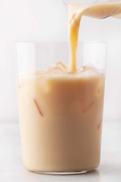 Pouring iced latte into a cup. 
