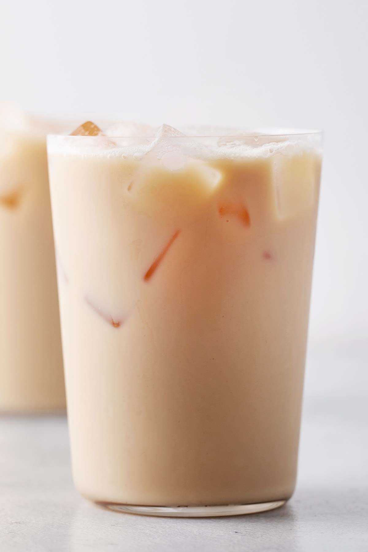 A finished Starbucks Iced London Fog Tea Latte copycat in a large, clear glass.