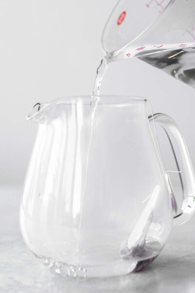 Pouring hot water into a tea pot. 