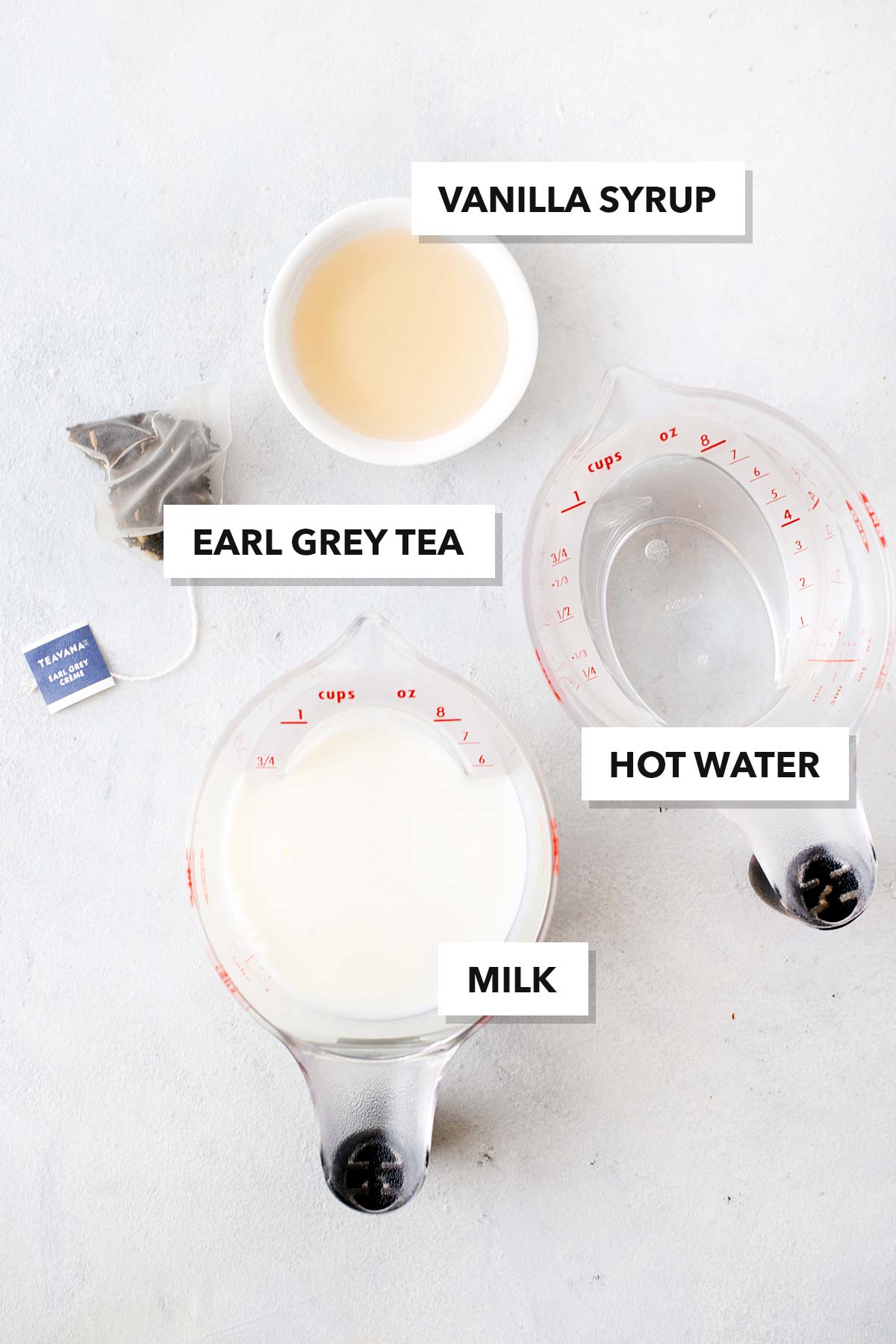 Starbucks London Fog Tea Latte Copycat recipe ingredients in measuring cups on a table.