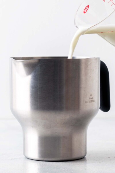 Pouring milk in an electric kettle. 