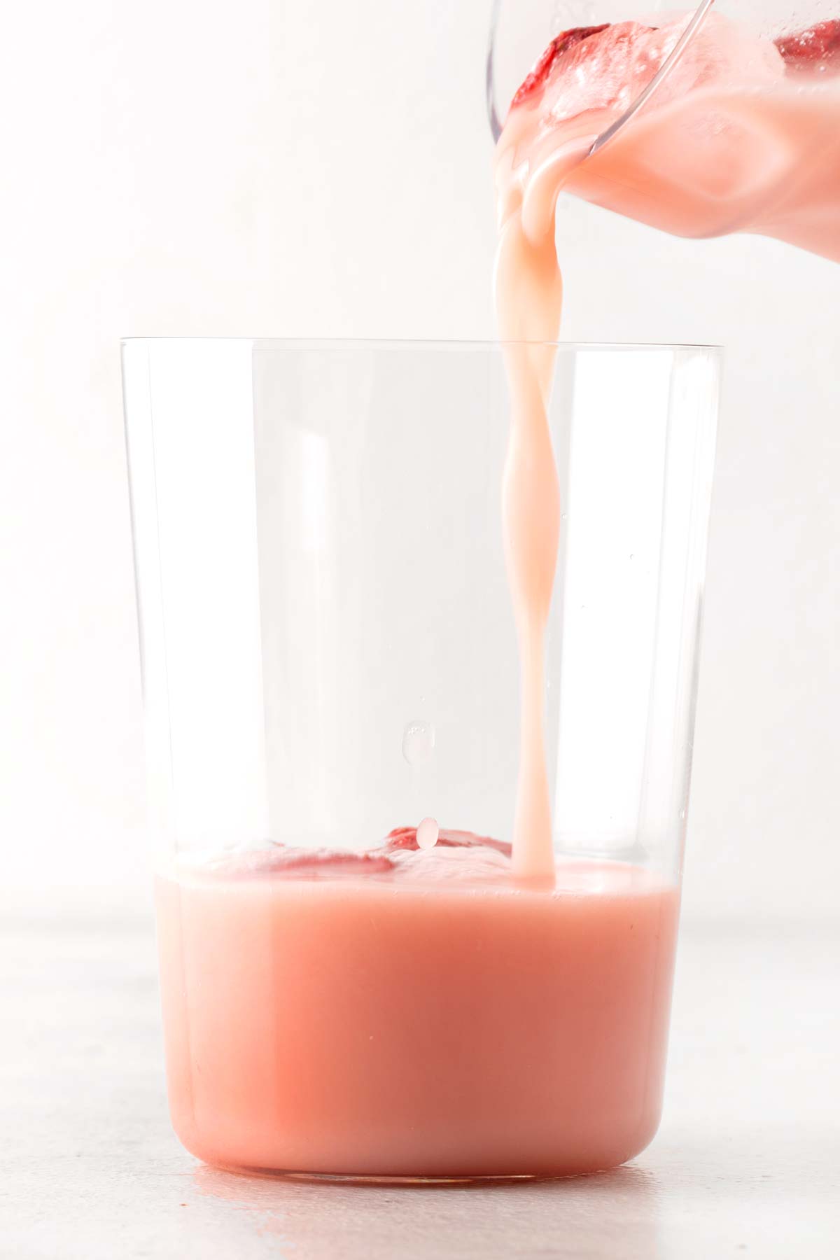 Pouring homemade Pink Drink into a cup.
