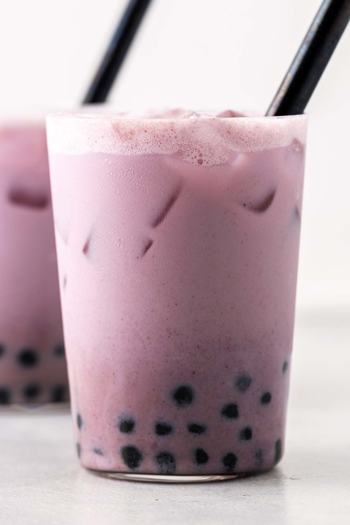 Purple Sweet Potato Boba Milk Tea in a cup with a black straw.