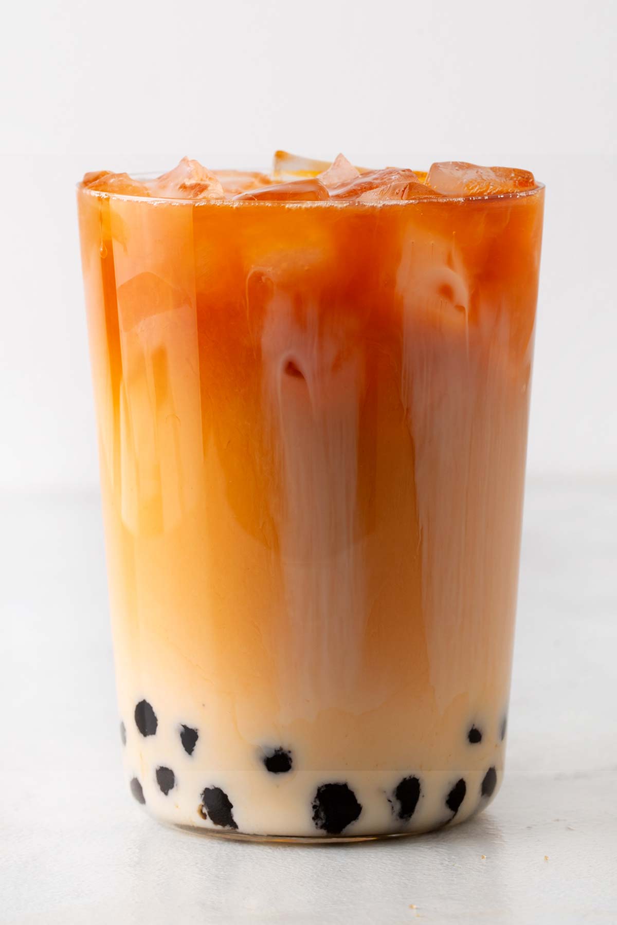Thai Bubble Tea in a glass with ice, without a straw.