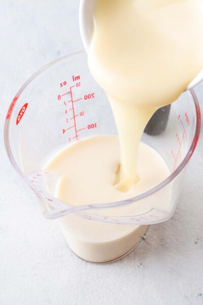 Pouring milk into a measuring cup. 